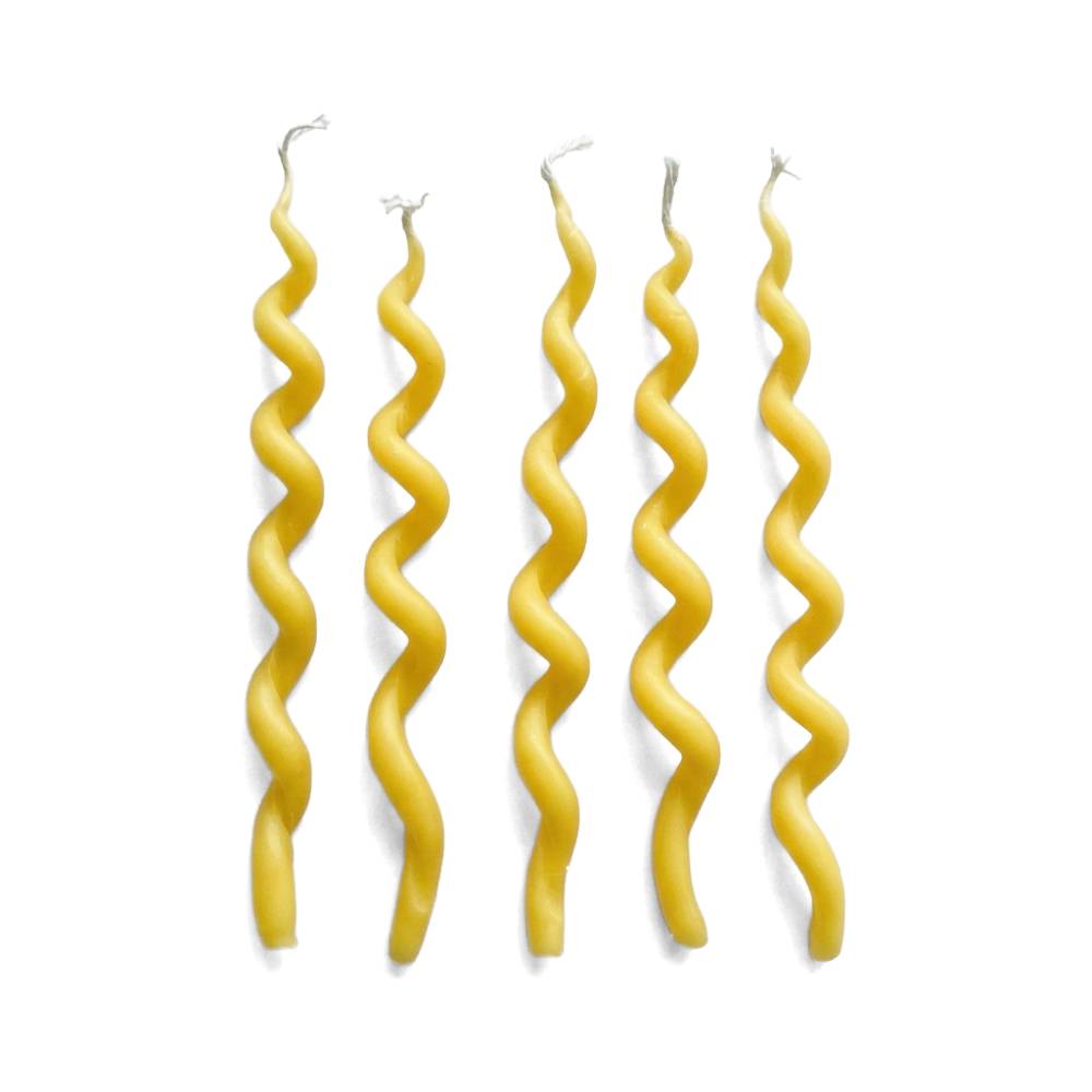 Five yellow spiral taper candles standing vertically on a plain white background.
