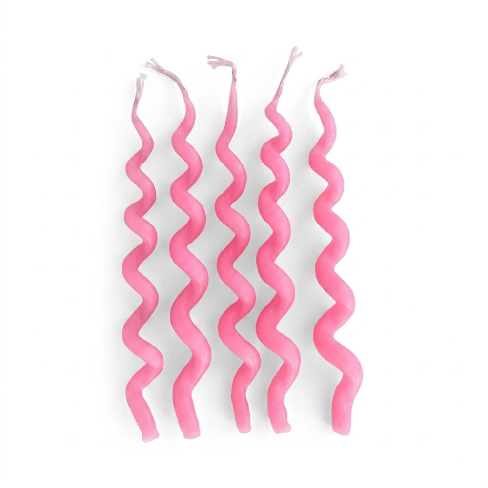Four pink spiral birthday candles standing upright on a plain white background.