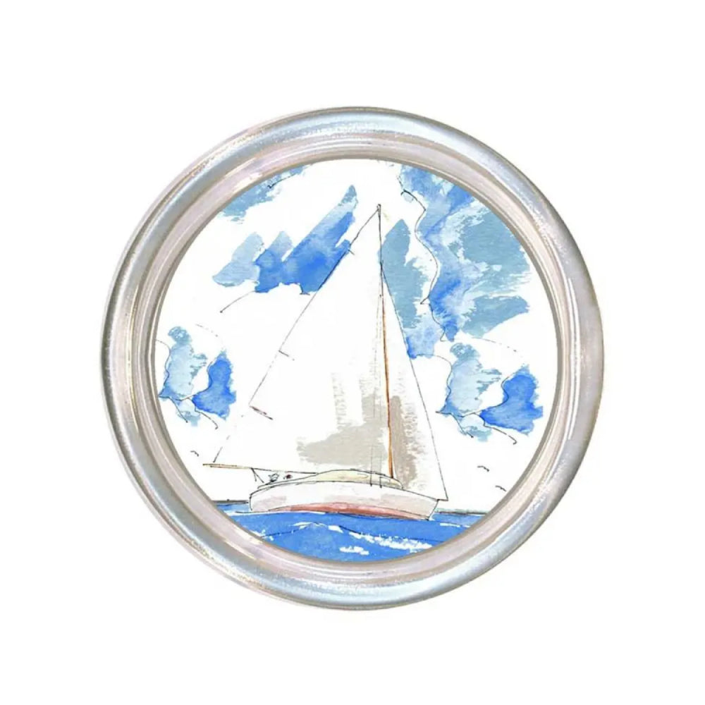 Round glass coaster with a rim with artwork of a sailboat  on the water and against the sky on a white background