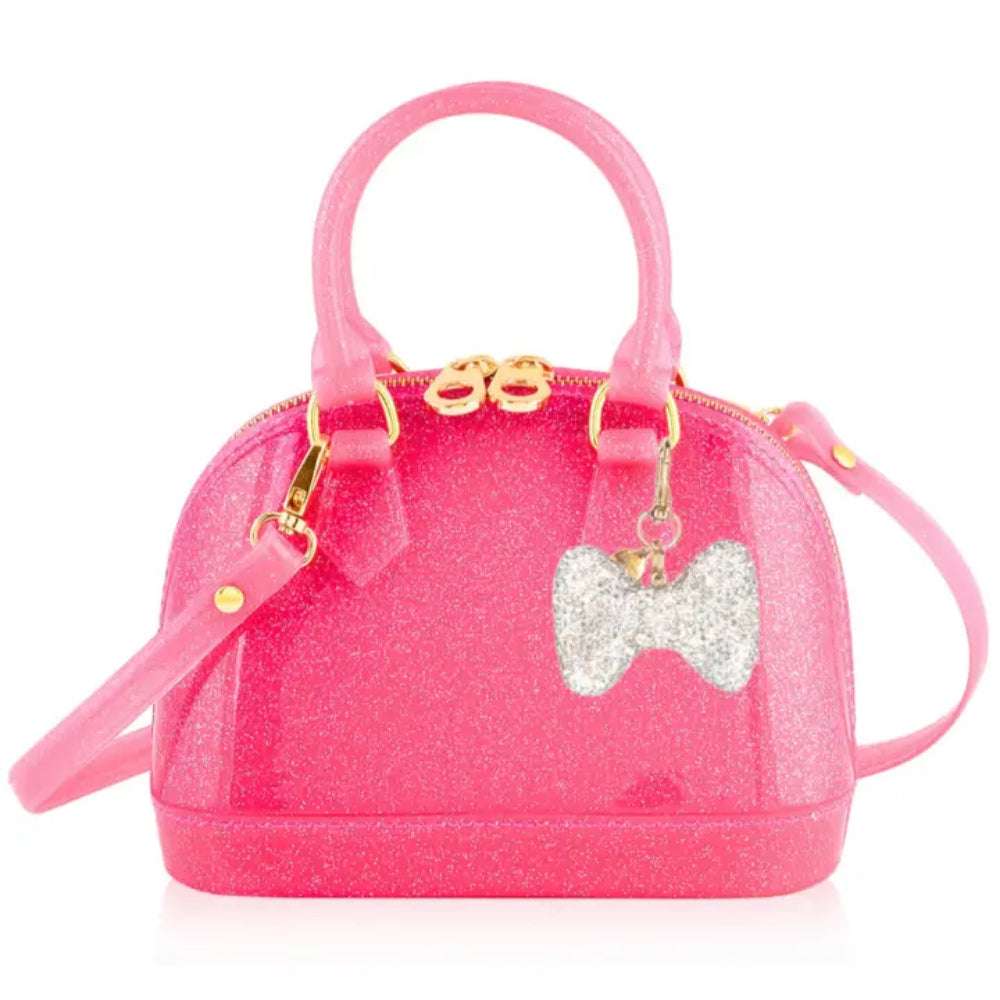 A pink glittery dome-shaped handbag with gold-tone hardware, featuring a silver glitter bow charm, a top handle, and a detachable shoulder strap on a white background.