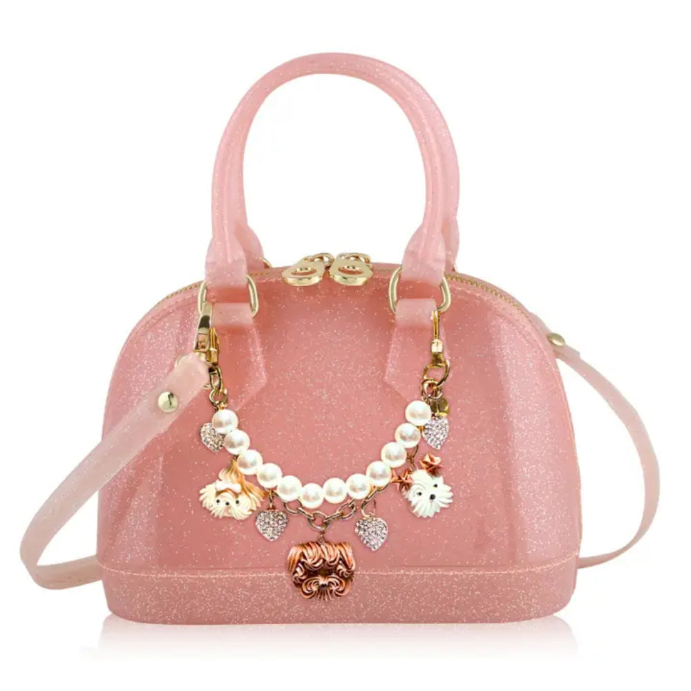 Pink handbag with decorative charms on a white background