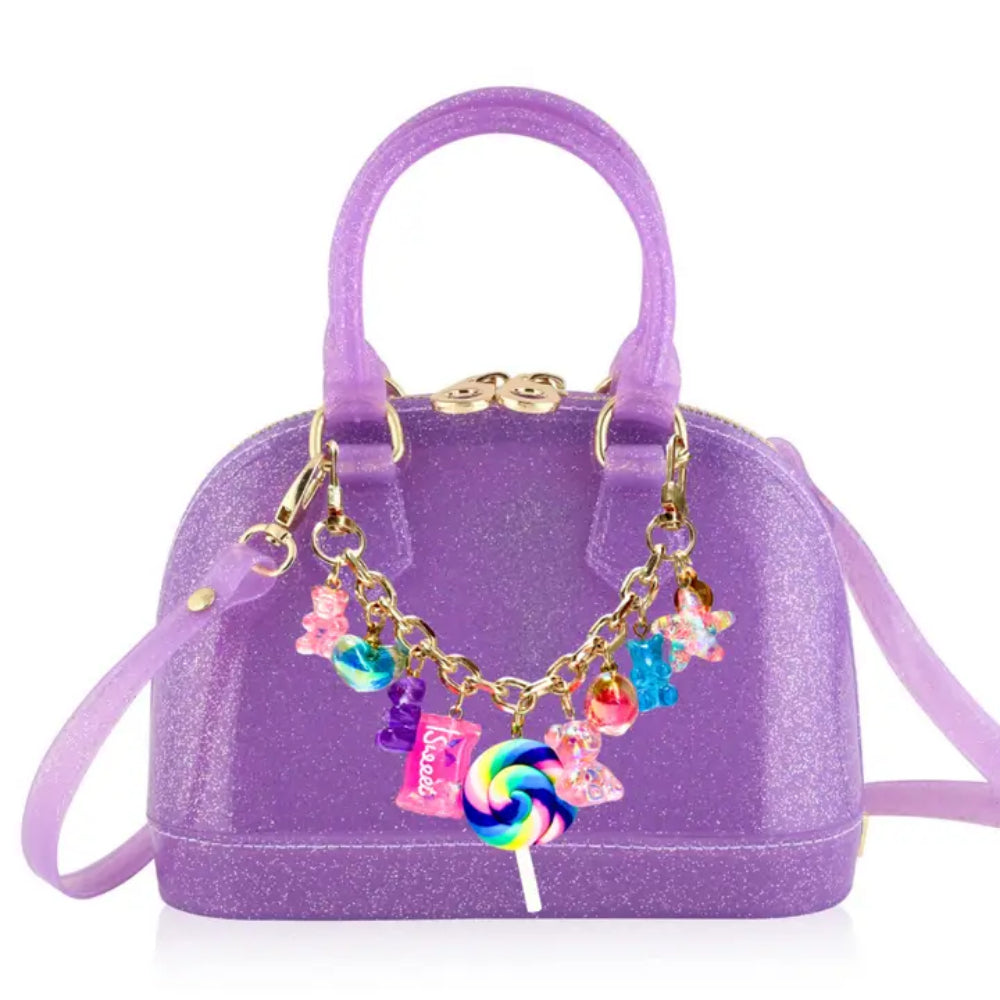 Purple handbag with colorful charm decorations on a white background