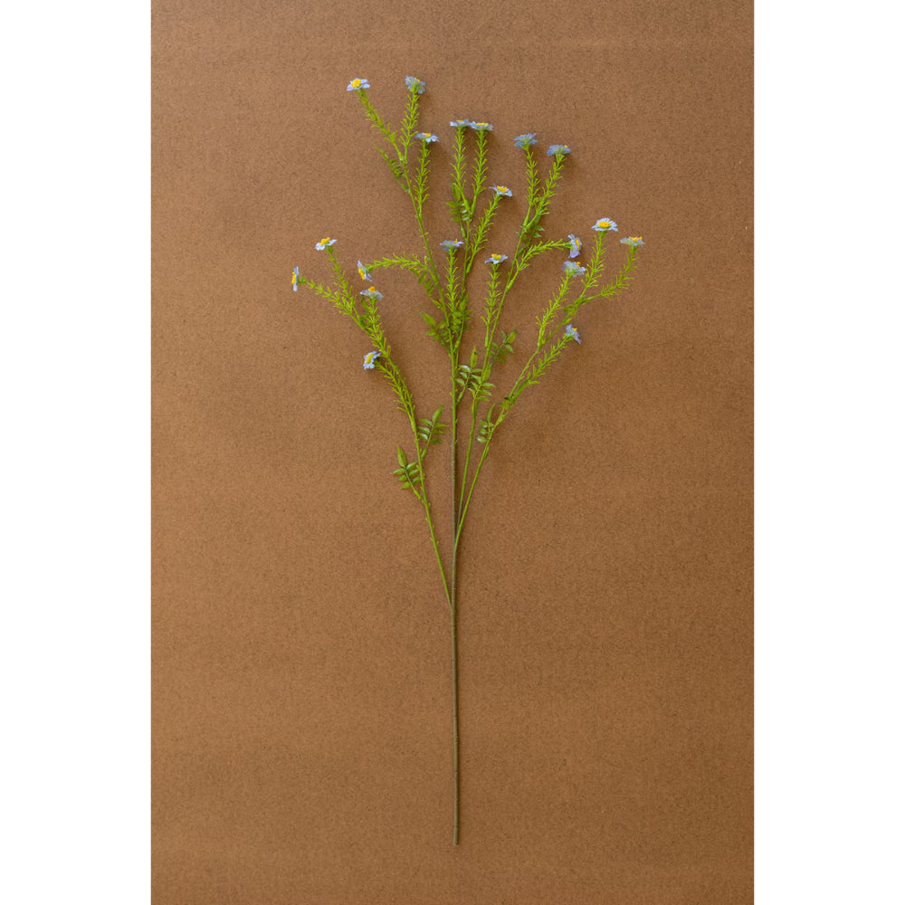 Artificial plant branch with small white flowers on a brown background
