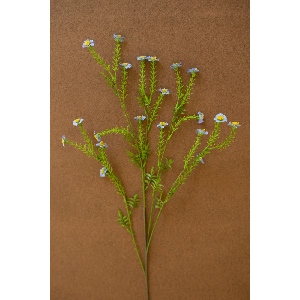 Artificial plant stem with small flowers on a brown background