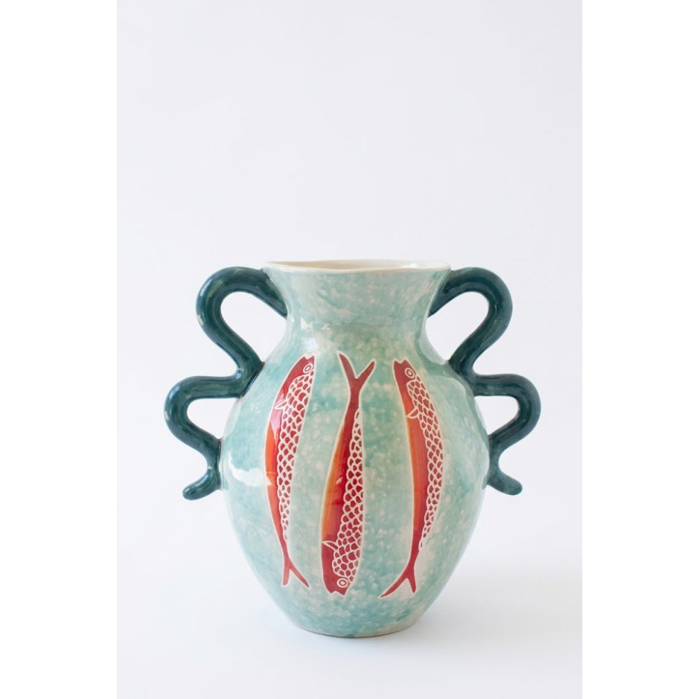 A ceramic vase with a textured light blue-green glaze, featuring three red fish motifs on the front and three dark teal handles, set against a plain white background.