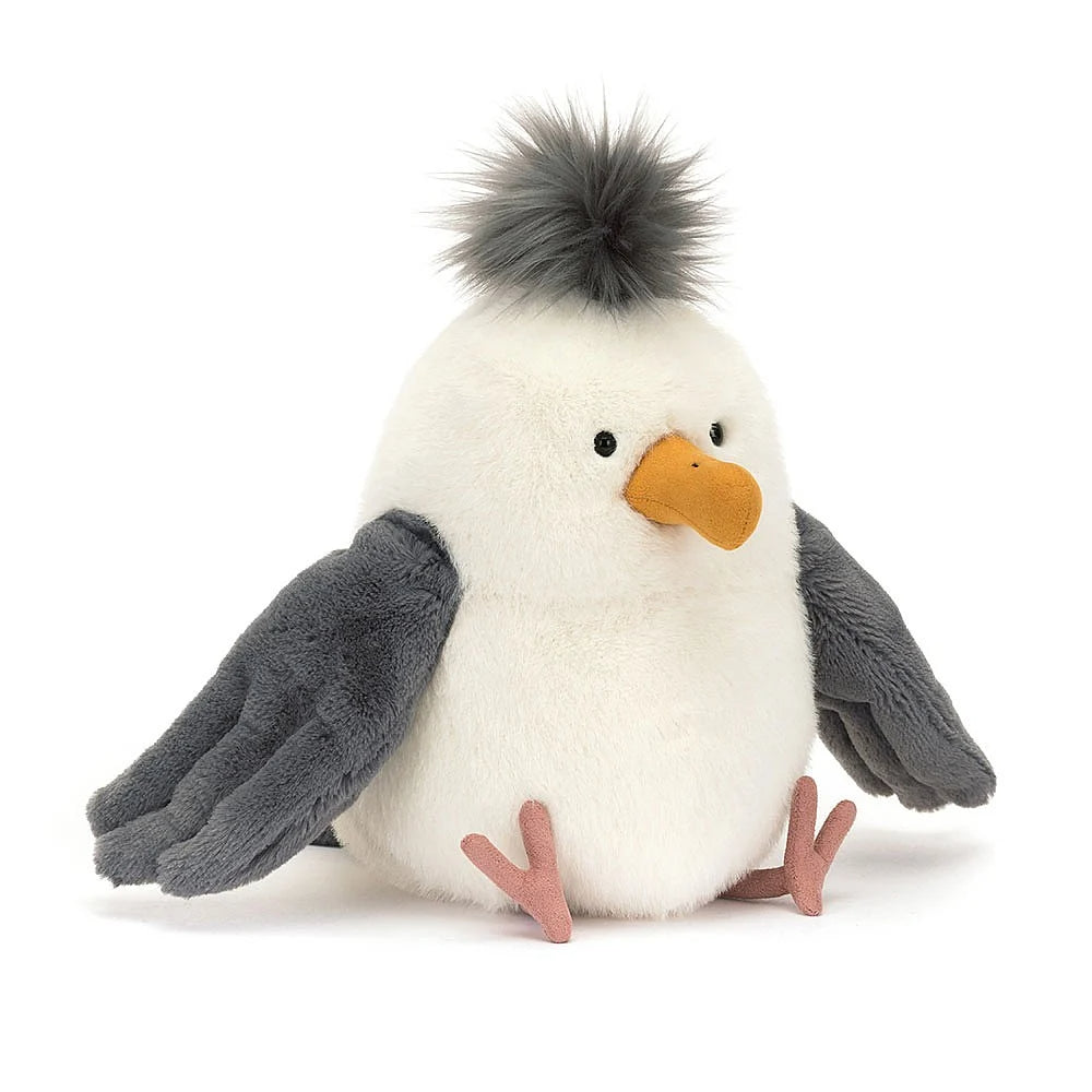 A side angled photo of a plush toy penguin with a white body, gray wings, and an orange beak on a white background