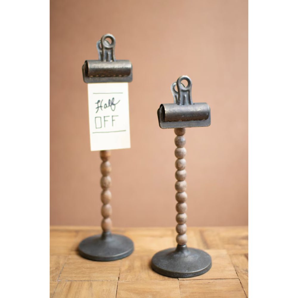 Two metal clip stands with wooden bases on a wooden surface.