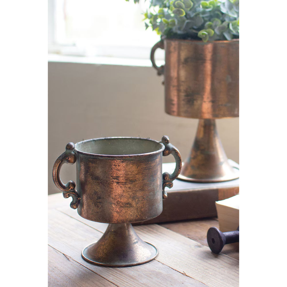 Bronze decorative vase on a wooden surface with a blurred background