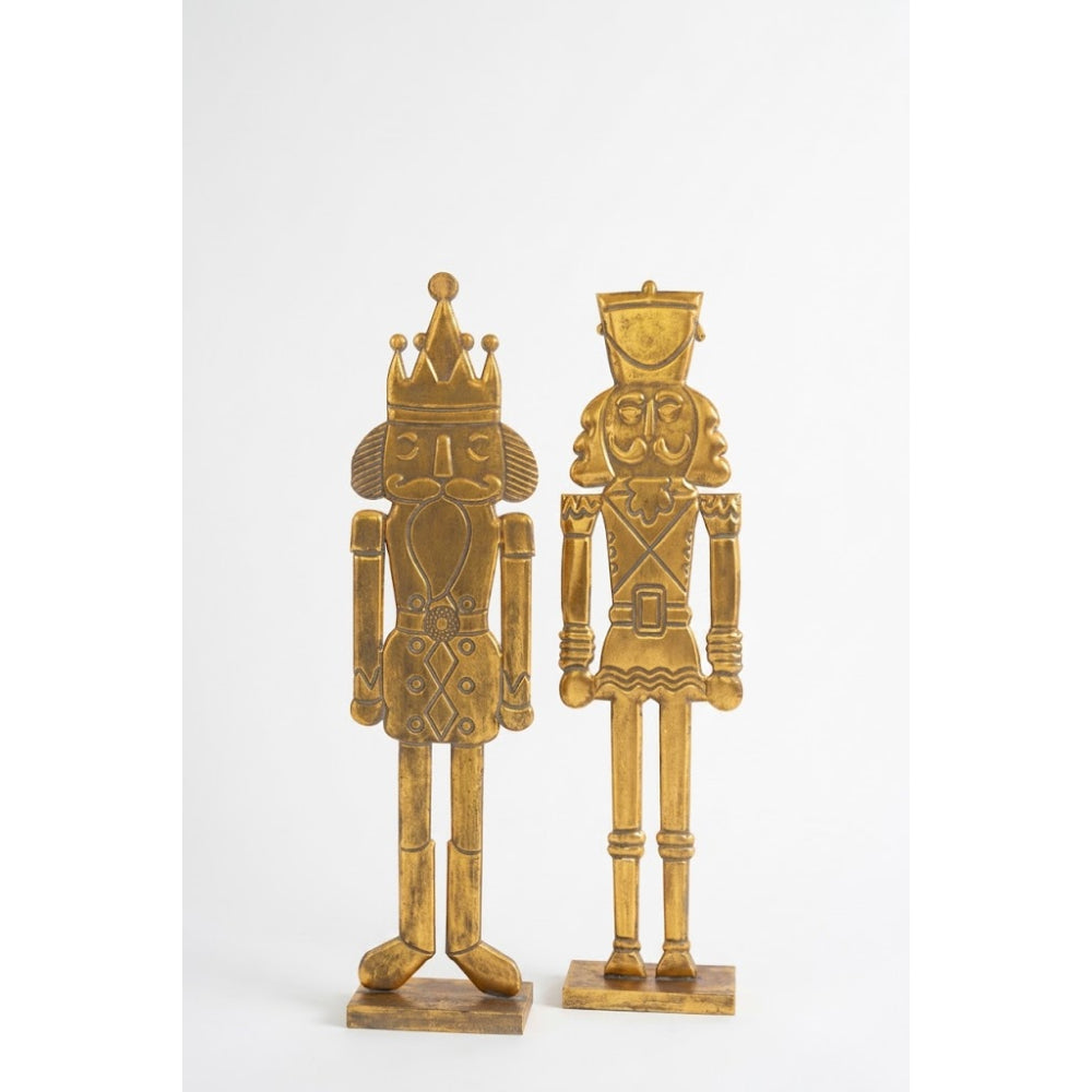 Two decorative nutcracker figurines in a metallic gold finish, standing side by side on a plain white background.