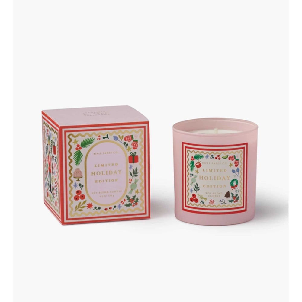A pink glass jar candle next to its matching pink and red illustrated gift box, labeled 'Limited Holiday Edition' by Good Apple Co.