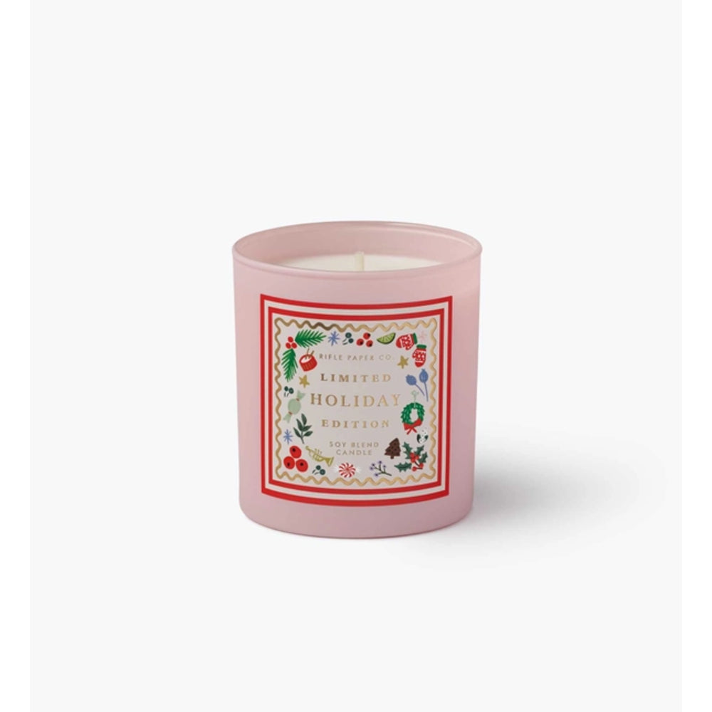 A pink glass jar candle with a white wick and a decorative front label reading 'Limited Edition Holiday Edition' surrounded by festive illustrations, shown on a light gray background.