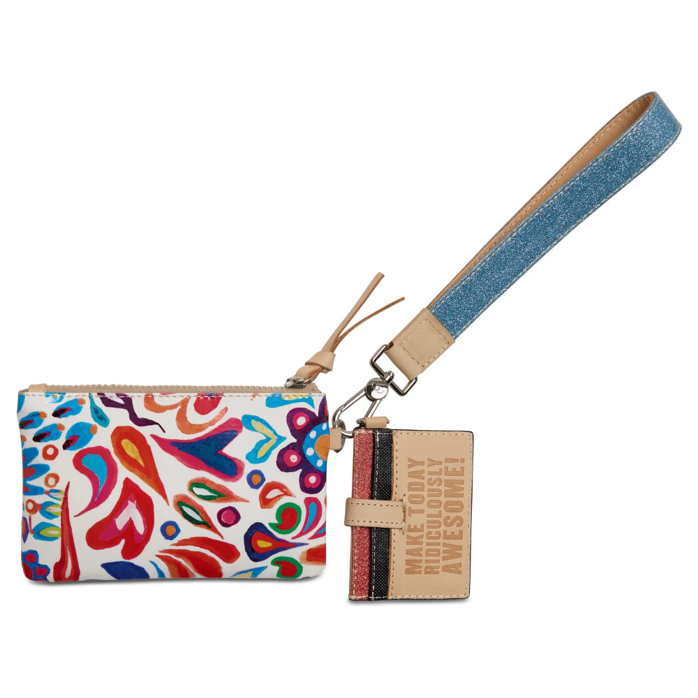 Colorful patterned pouch with a denim strap and small notebook on a white background