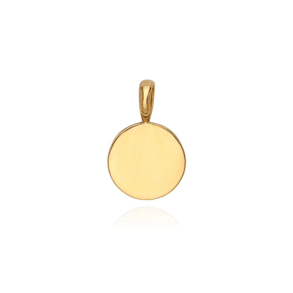 A polished yellow gold round disc pendant with a smooth, blank face and a matching bail at the top, shown on a clean white background with a soft reflection below.
