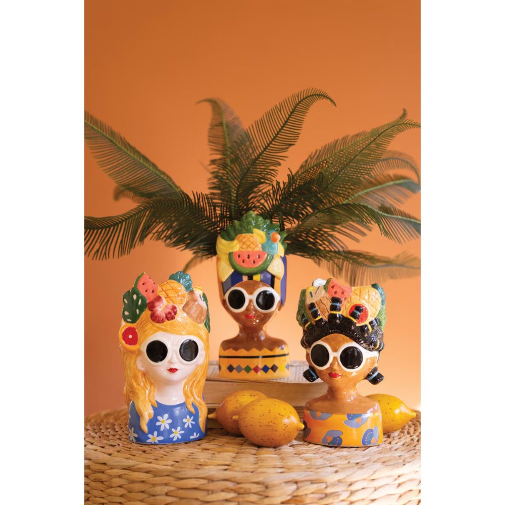 Colorful ceramic figurines with decorative hairstyles on a woven surface with an orange background