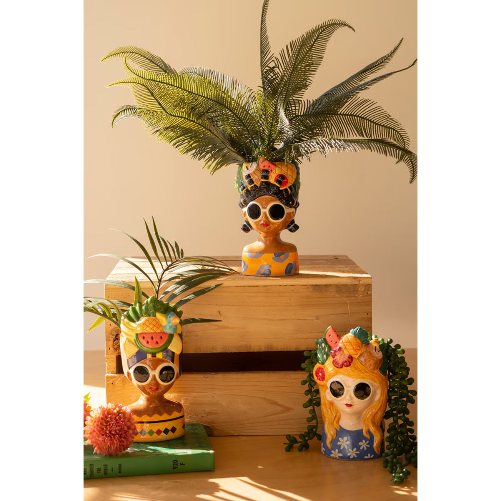 Decorative figurines with floral and fruit-themed designs on a wooden box.