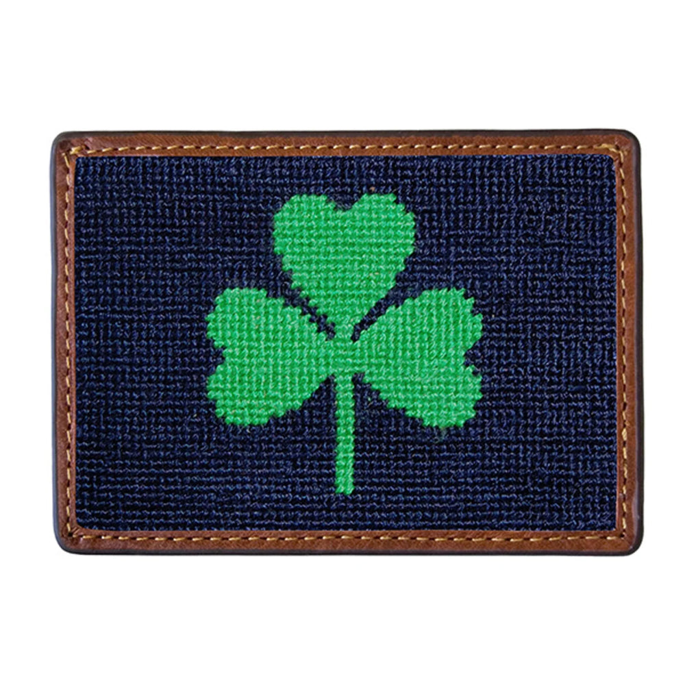Navy needlepoint cardholder with green shamrock design on a white background