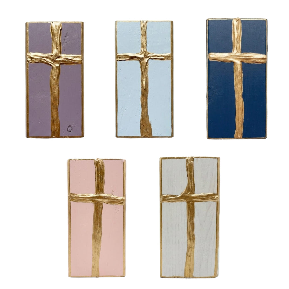 Gold cross decorative painted wooden blocks on a white background