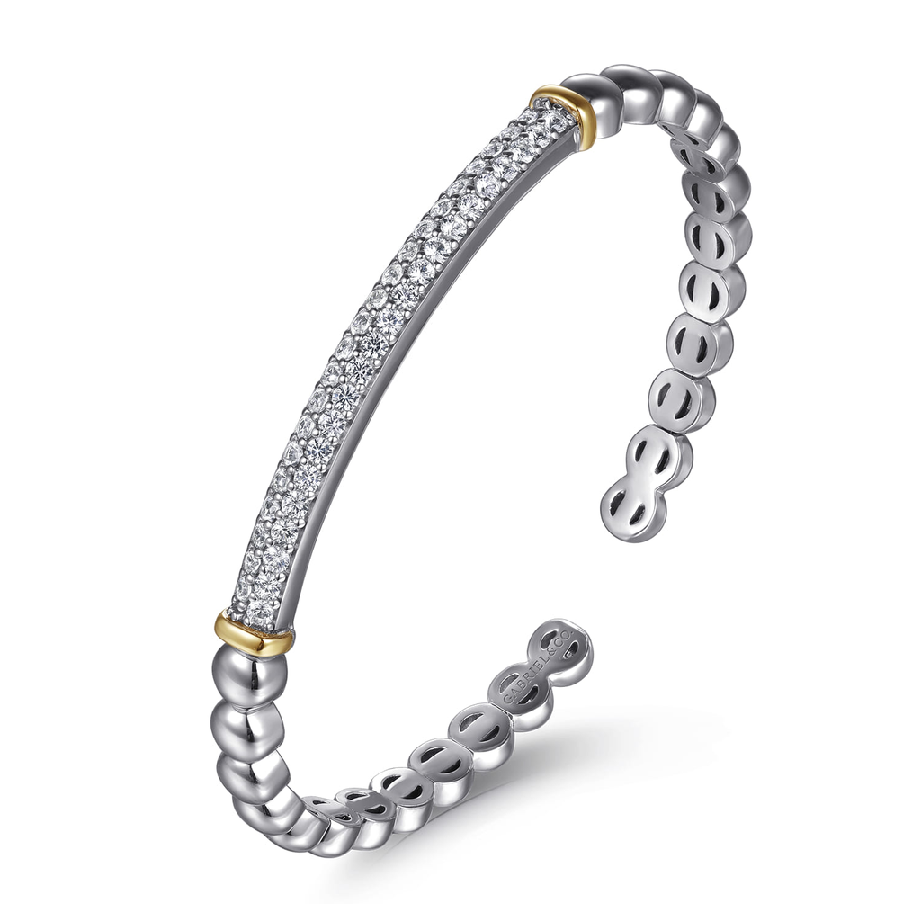 Silver bracelet with gold accents on a white background