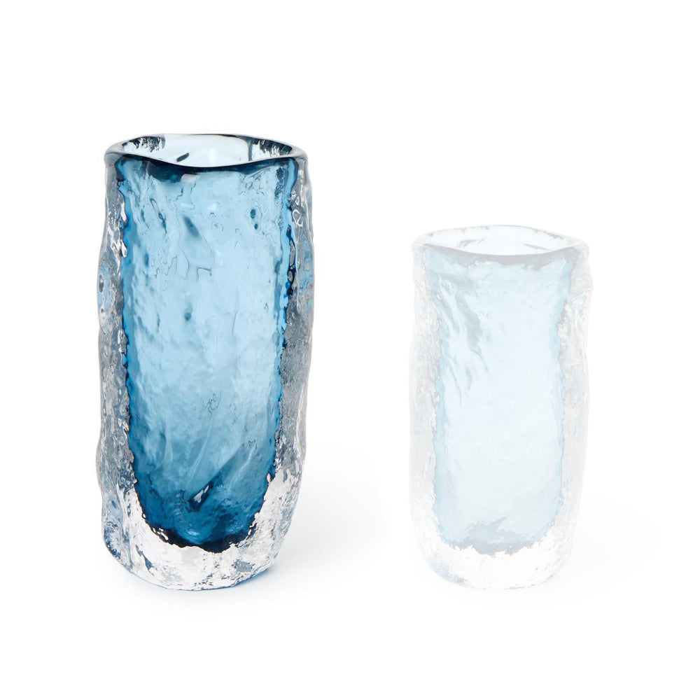 Large blue glass vase with a translucent blue a core on a white backround.