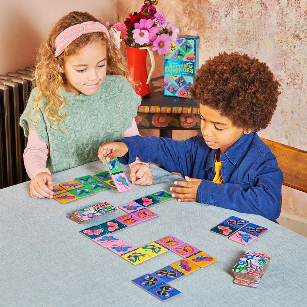 Two children playing with colorful card games at a table.