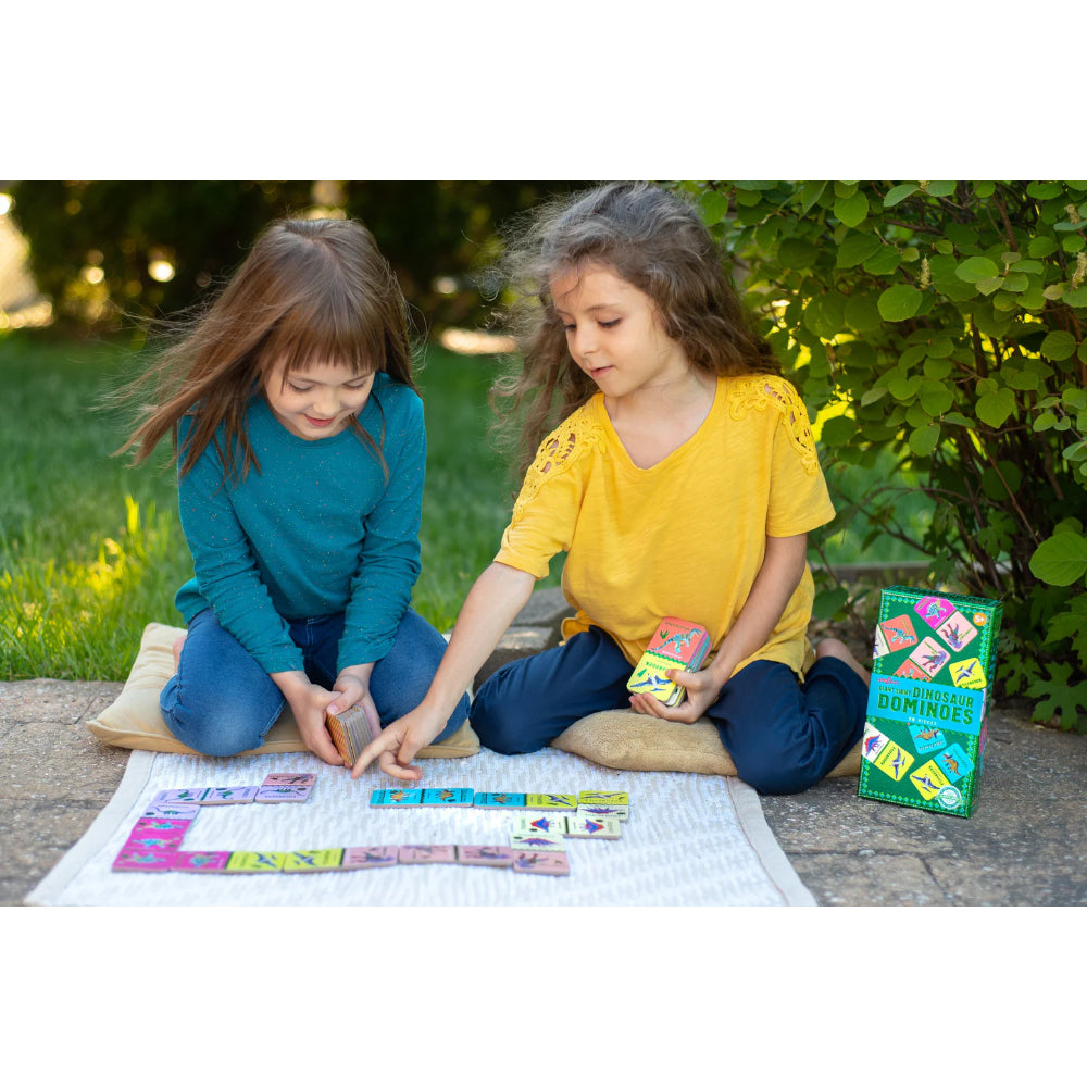 Two children playing with a game outdoors on a blanket