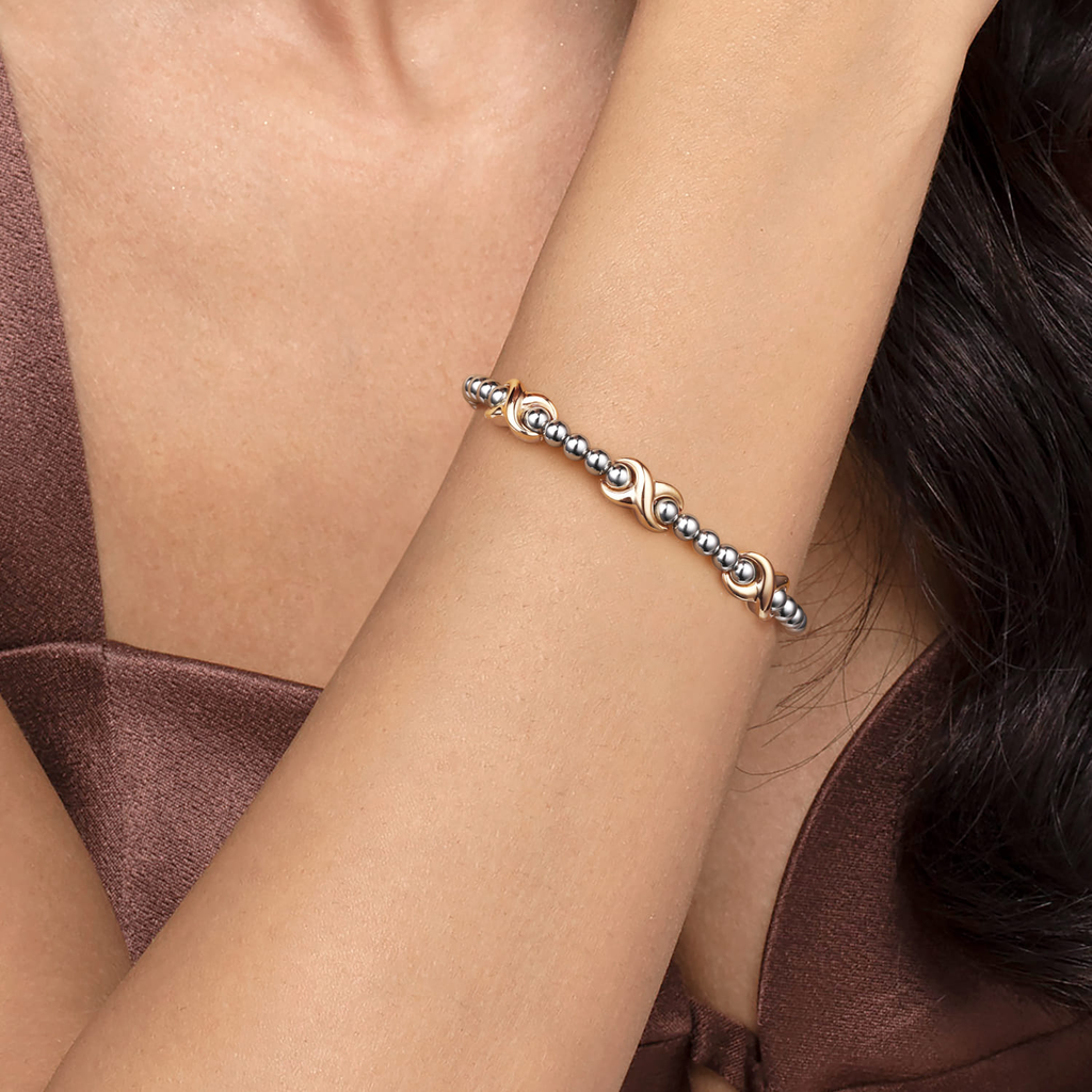 Silver bracelet on a person's wrist with a brown top