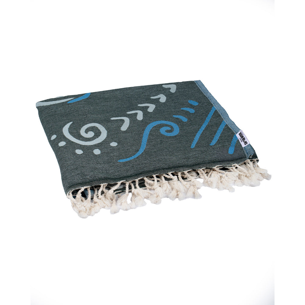 Folded towel with decorative patterns and a white tassel edge on a white background.