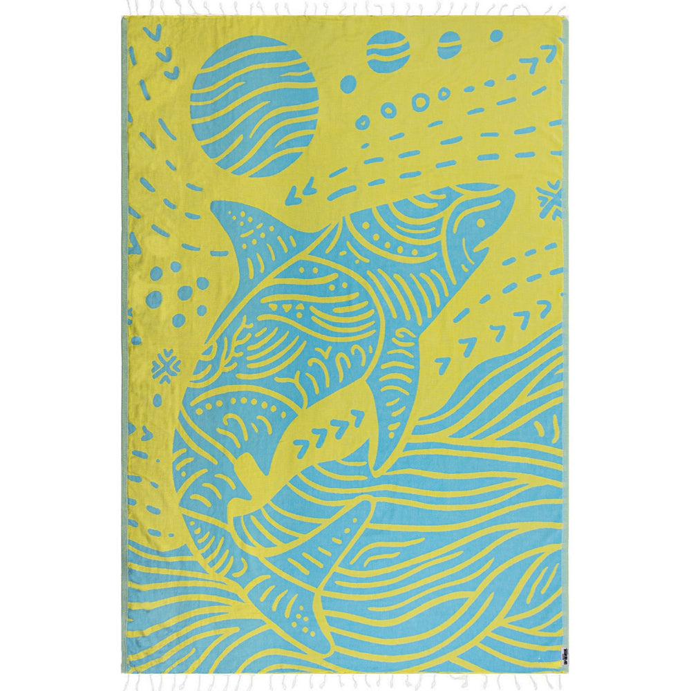 Side one of a beach towel with a blue and yellow shark design with a white tassel edge on a white background.