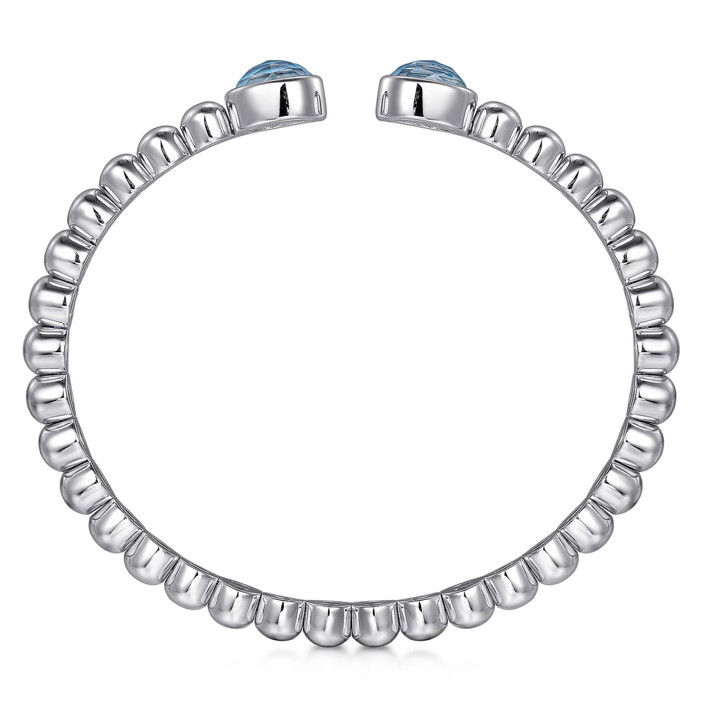 Silver ring with blue gemstones on a white background