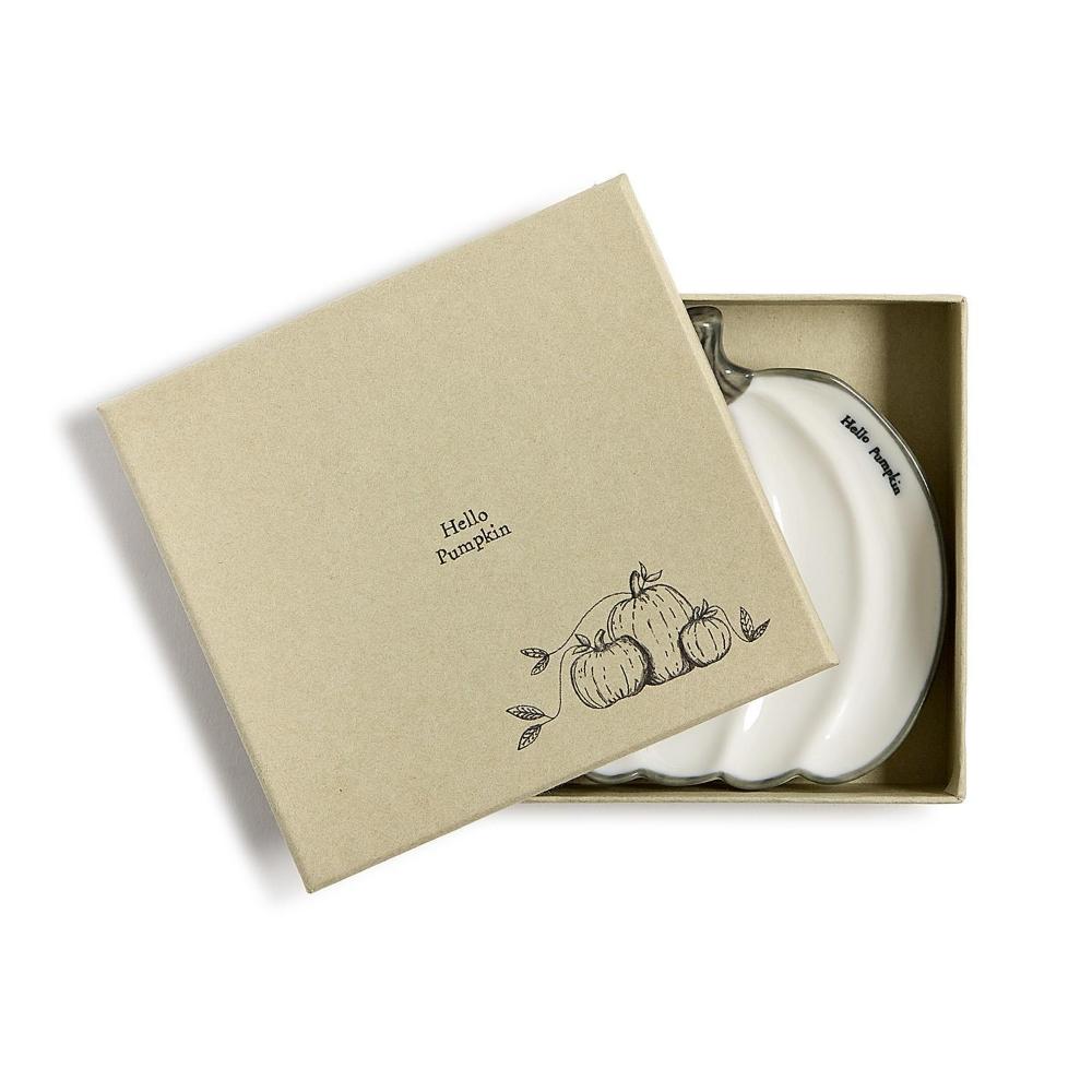 A white ceramic pumpkin-shaped dish with a scalloped rim and a handle, presented in a beige gift box with a matching lid printed with 'Hello Pumpkin' and a pumpkin illustration.