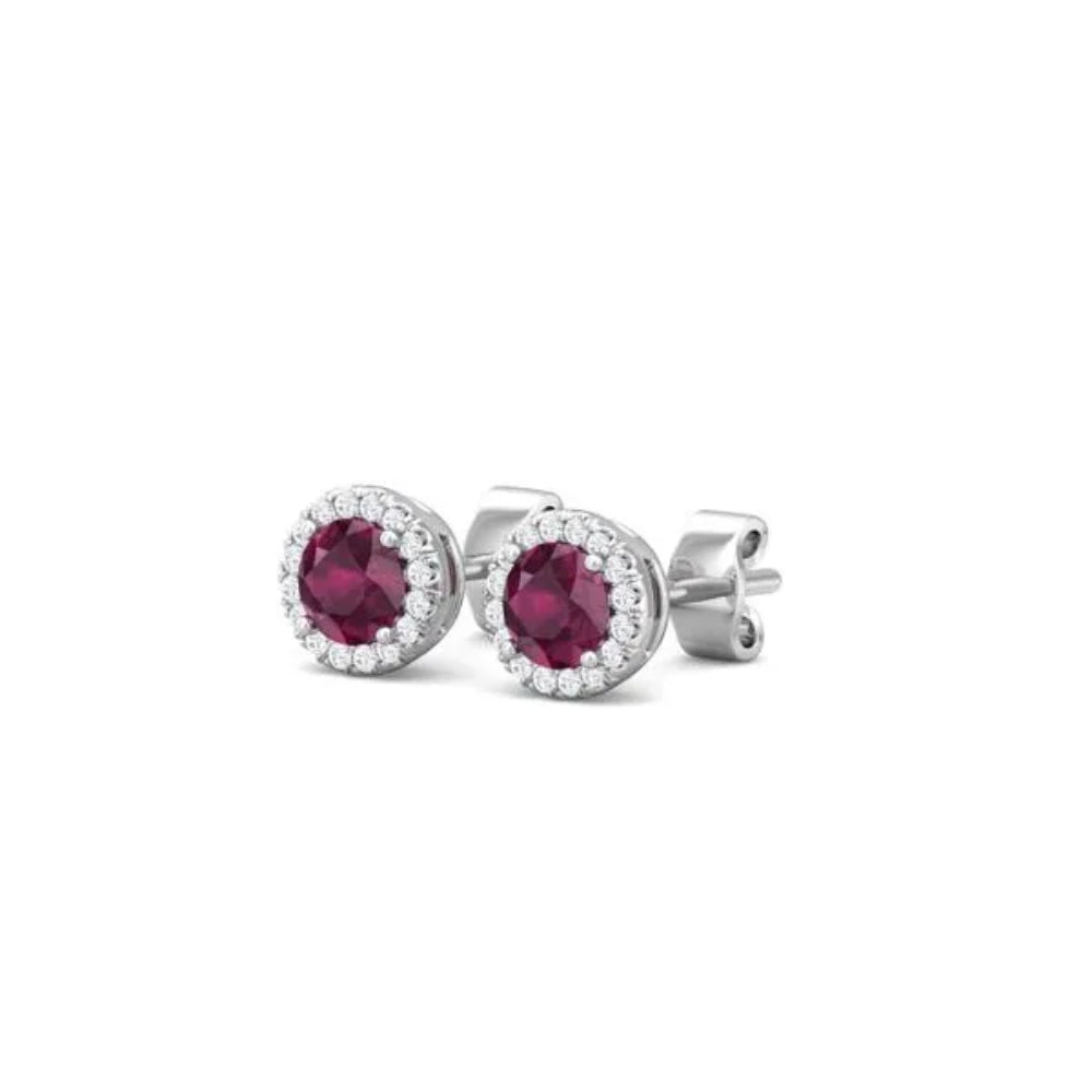 White gold ruby and diamond halo stud earrings on a white background