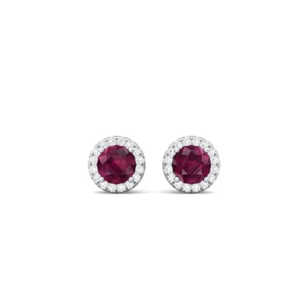 White gold ruby and diamond halo stud earrings on a white background
