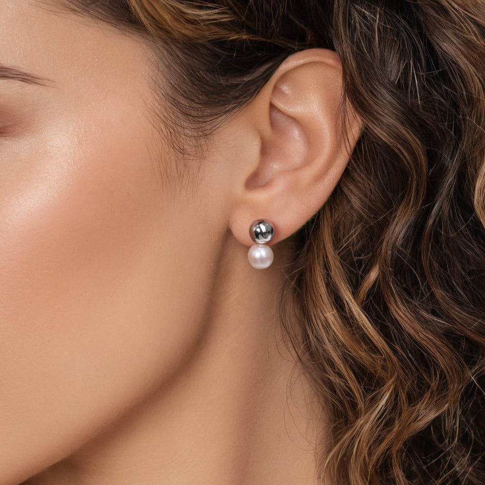 Close up of woman wearing silver and Pearl stud earring 