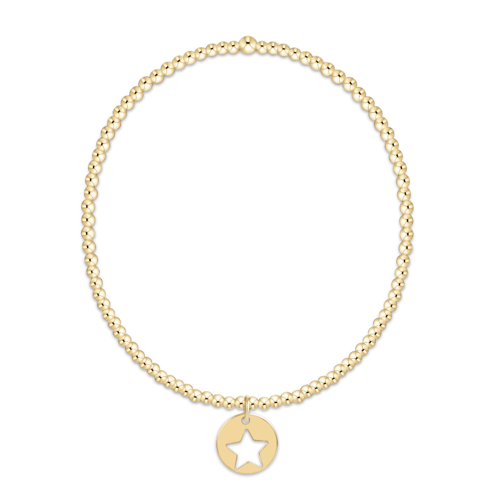 A delicate gold chain bracelet with a small circular disc pendant featuring a star cutout, displayed against a solid white background.