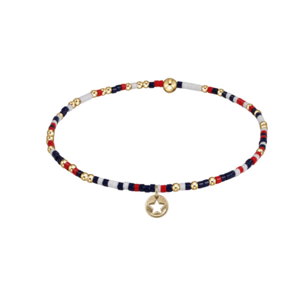 Bracelet with red, white, and blue beads and a gold star charm on a white background