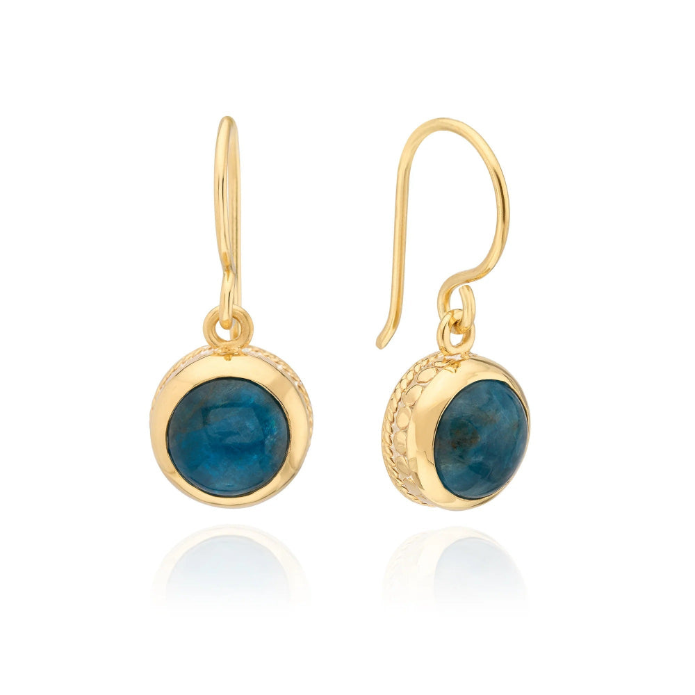 A pair of gold drop earrings with round blue gemstone bezels