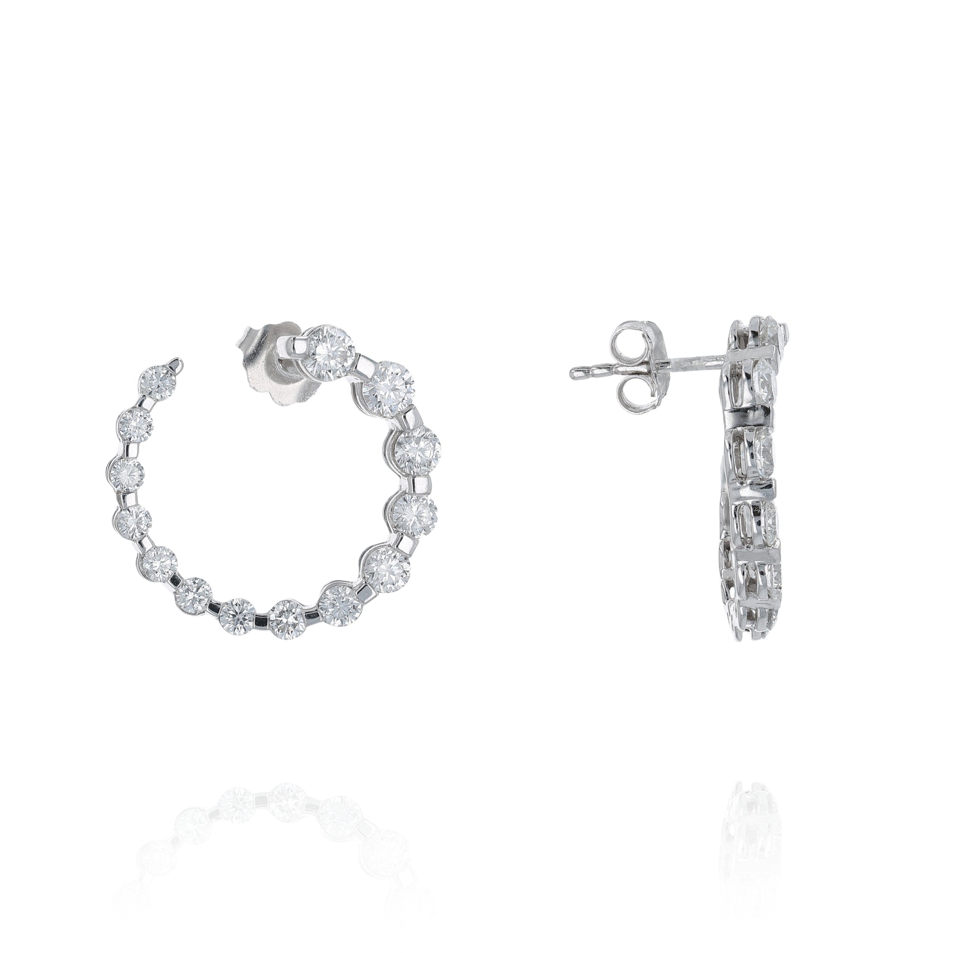 Pair of white gold drop earrings with graduated diamonds on a white background