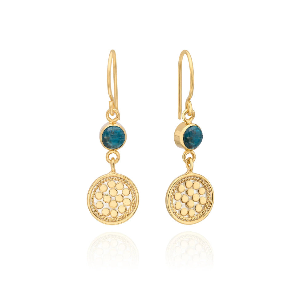 A pair of gold toner dangle earrings with round blue gemstone accents and textured circular drop pendants