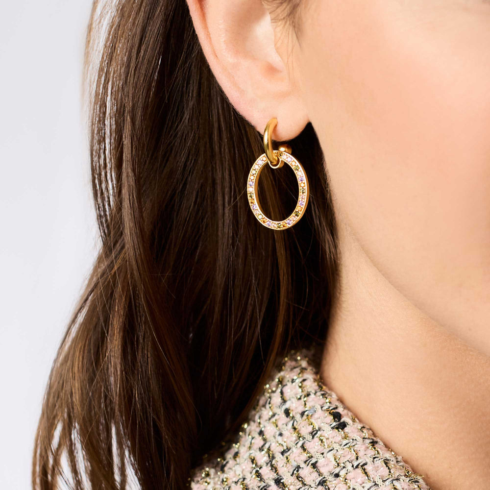 Gold hoop earring worn by a person with dark hair.
