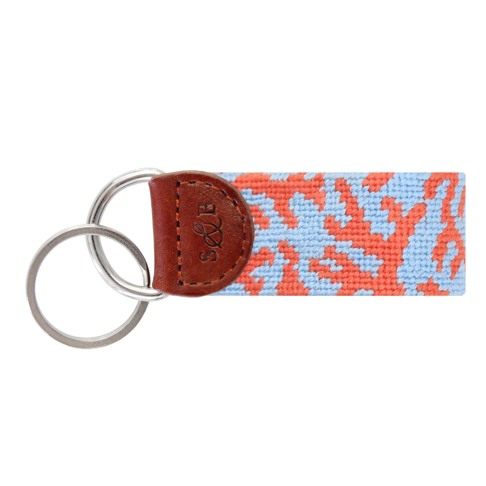 Keychain with patterned strap and brown leather accent on a white background