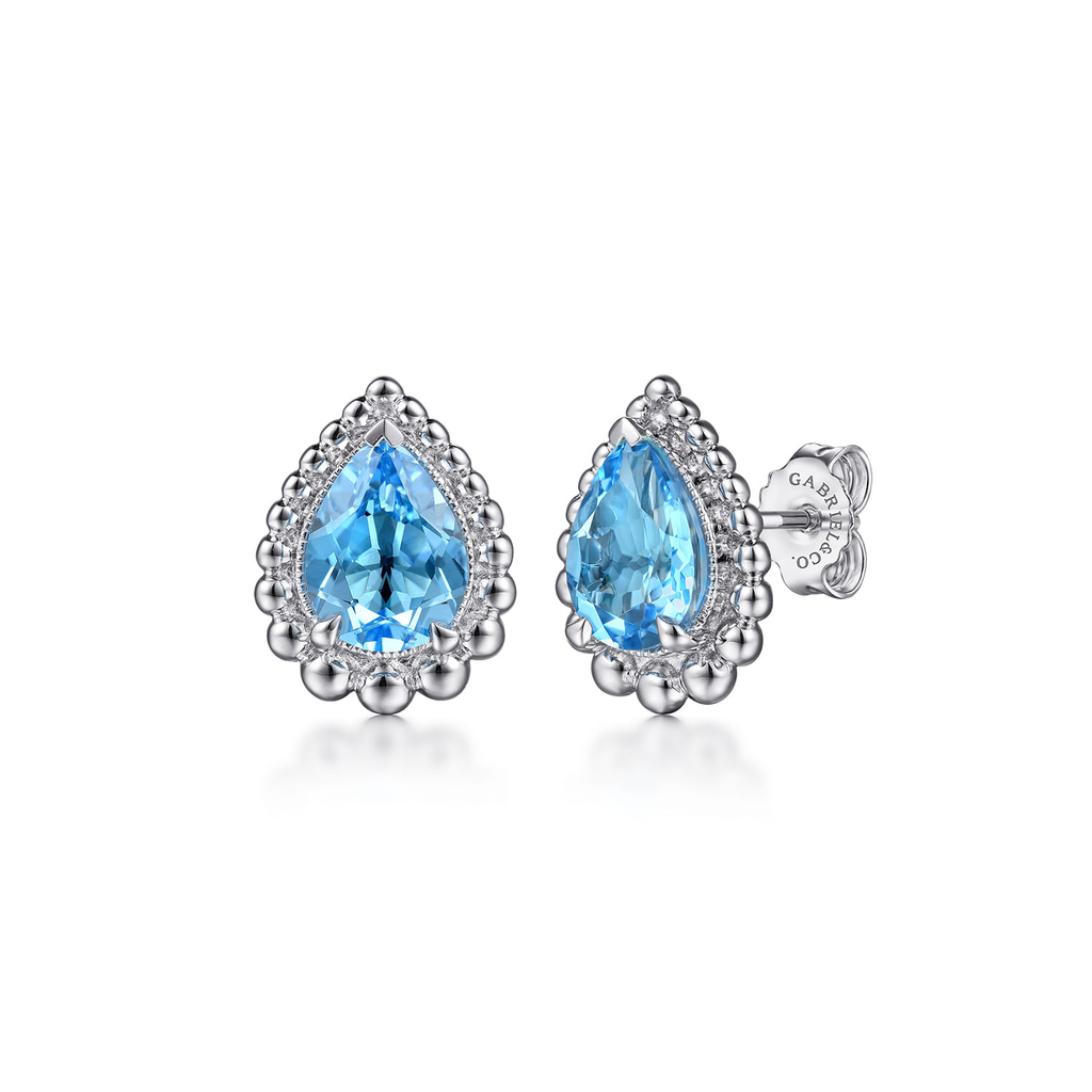 Pair of silver earrings with blue teardrop-shaped gemstones on a white background