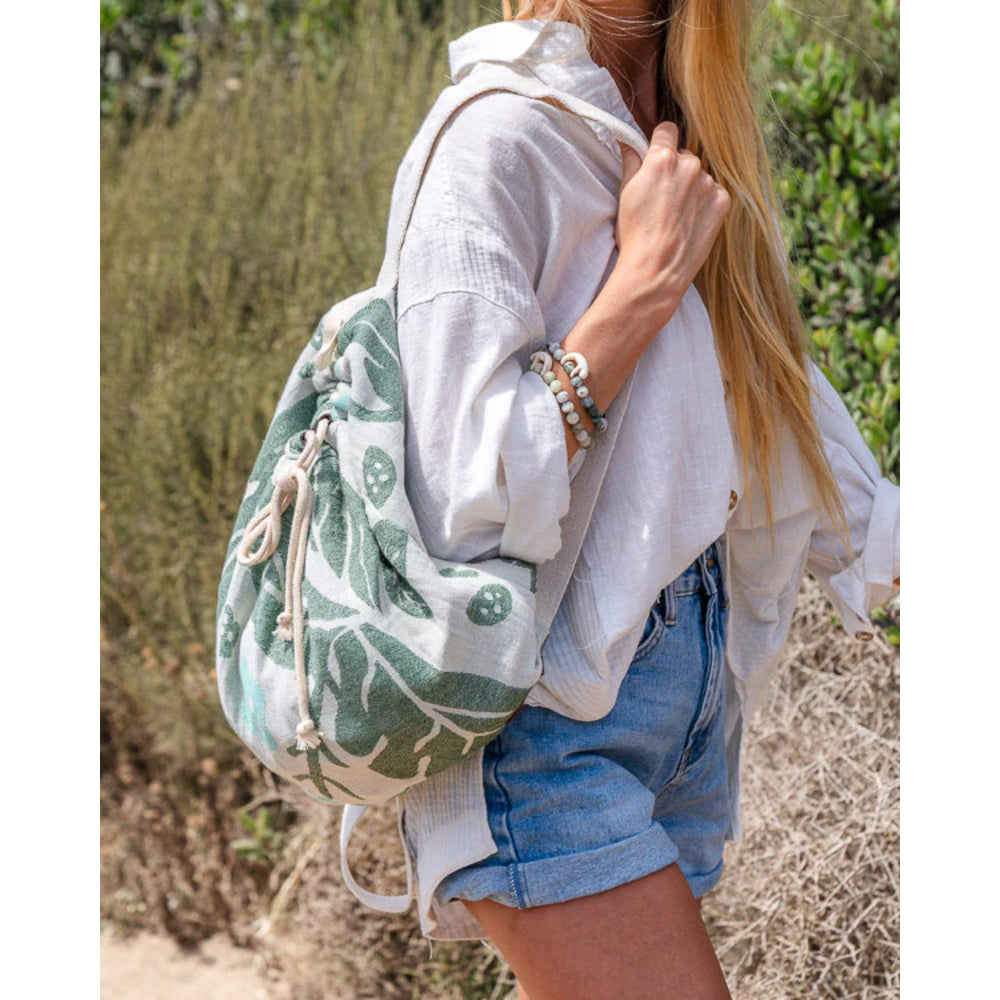 Person wearing a green leaf-patterned backpack outdoors
