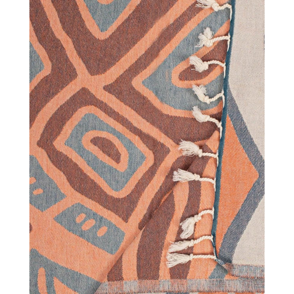 Close-up of a patterned towel with geometric design in orange, blue, and beige.