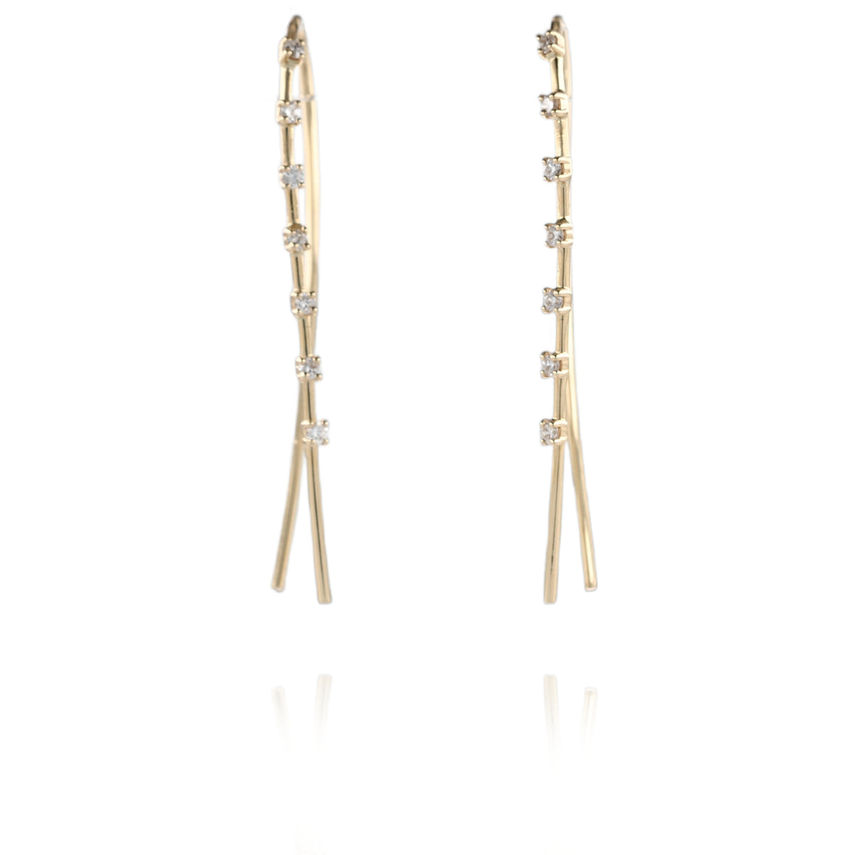 A pair of gold drop earrings with a slim, branching design accented by small clear gemstones, shown against a solid white background.