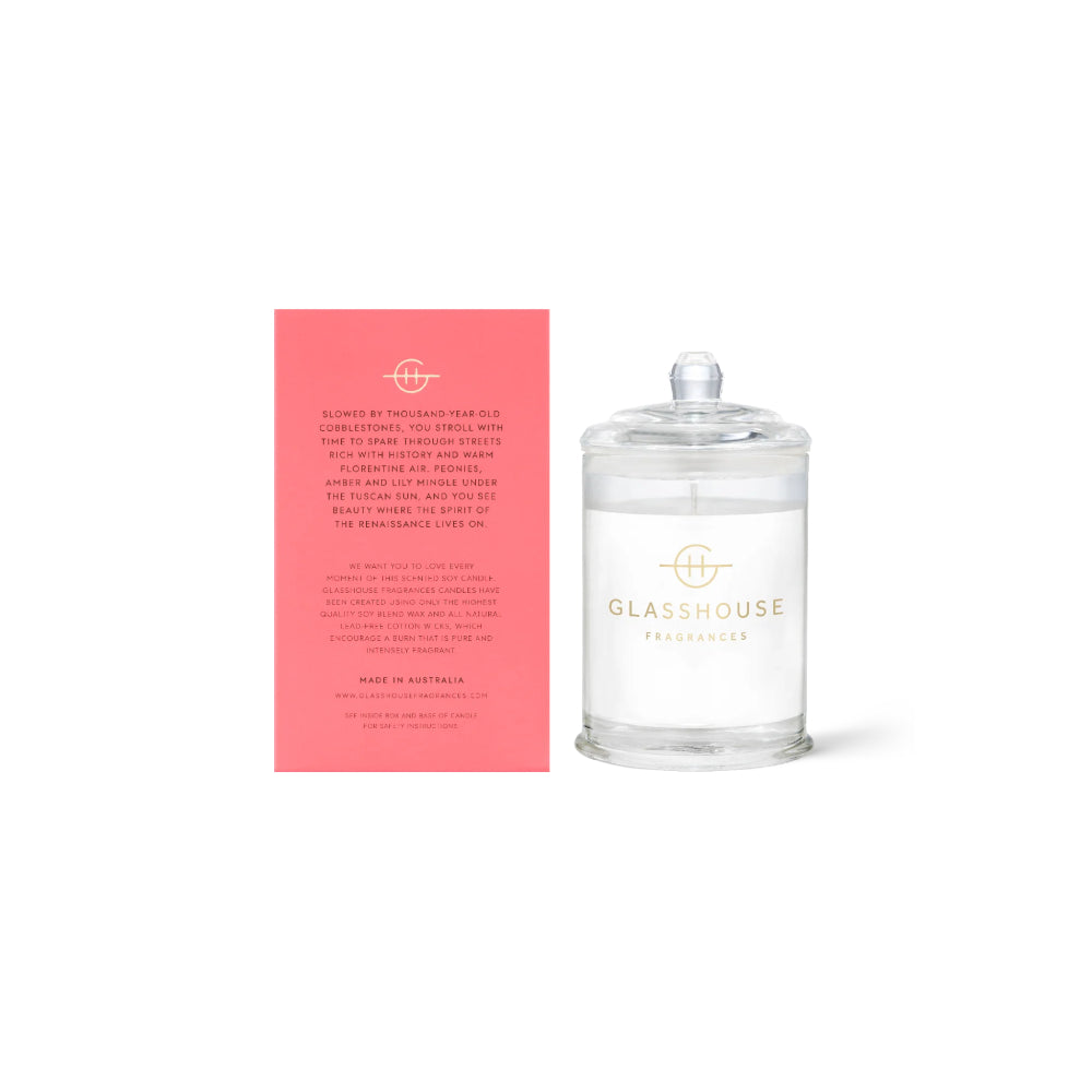 Clear glass candle with pink packaging featuring text and 'Glashouse' branding on a white background