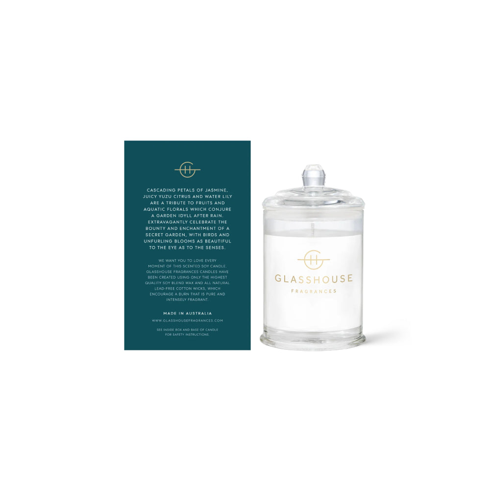 The back of a glasshouse candle  green packaging with text and  a clear "Velvet Rhapsody" candle  on a white background.