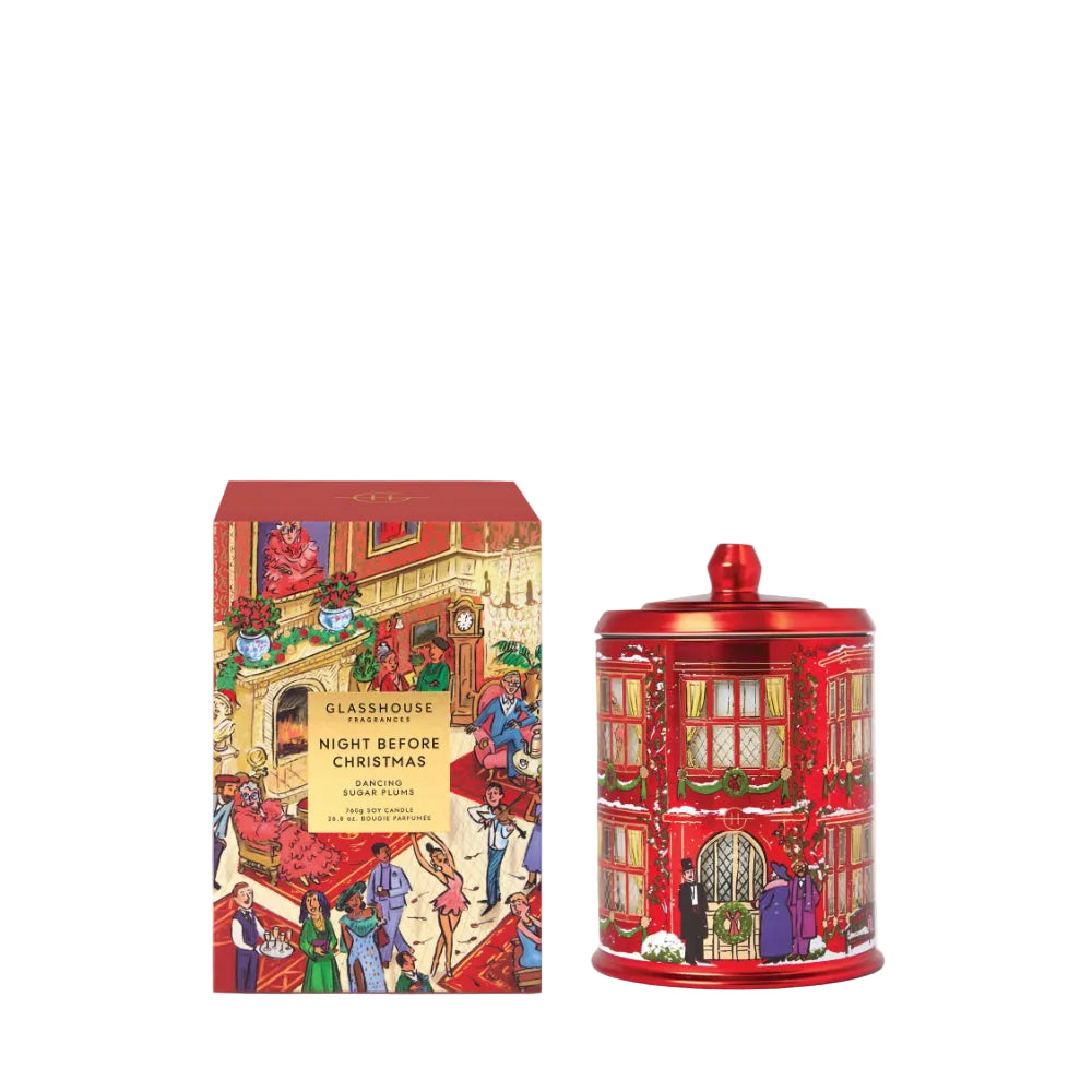 A red cylindrical tin and its matching retail box from Glasshouse London's 'Night Before Christmas' scent line, both decorated with festive holiday street scene illustrations.