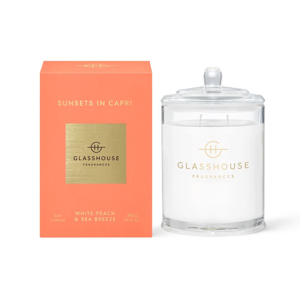 Glasshouse Fragrances clear candle "Sunsets In Capri" and orange packaging on a white background.