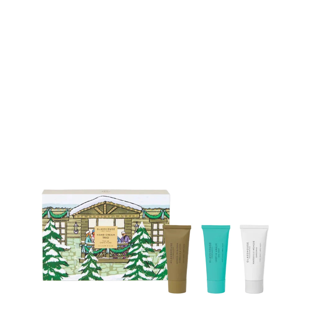 A gift set featuring a illustrated winter cabin box and three cosmetic tubes in brown, teal, and white, shown on a clean white background.