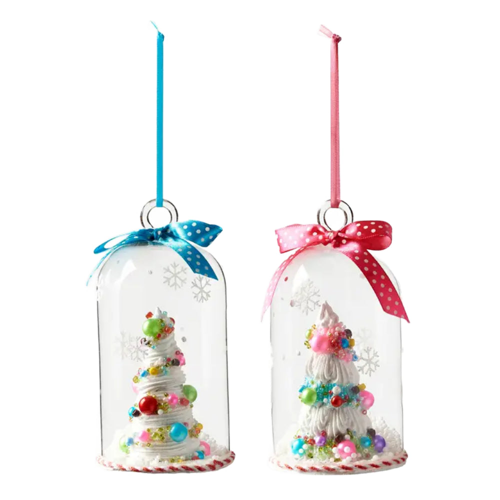 Two clear glass dome Christmas ornaments hanging side by side, each containing a small white frosted tree decorated with colorful beads, sequins, and glitter, with one blue ribbon and one pink ribbon.
